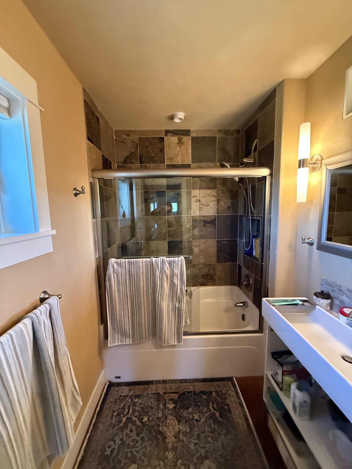 The original tub and shower combination with dark tile