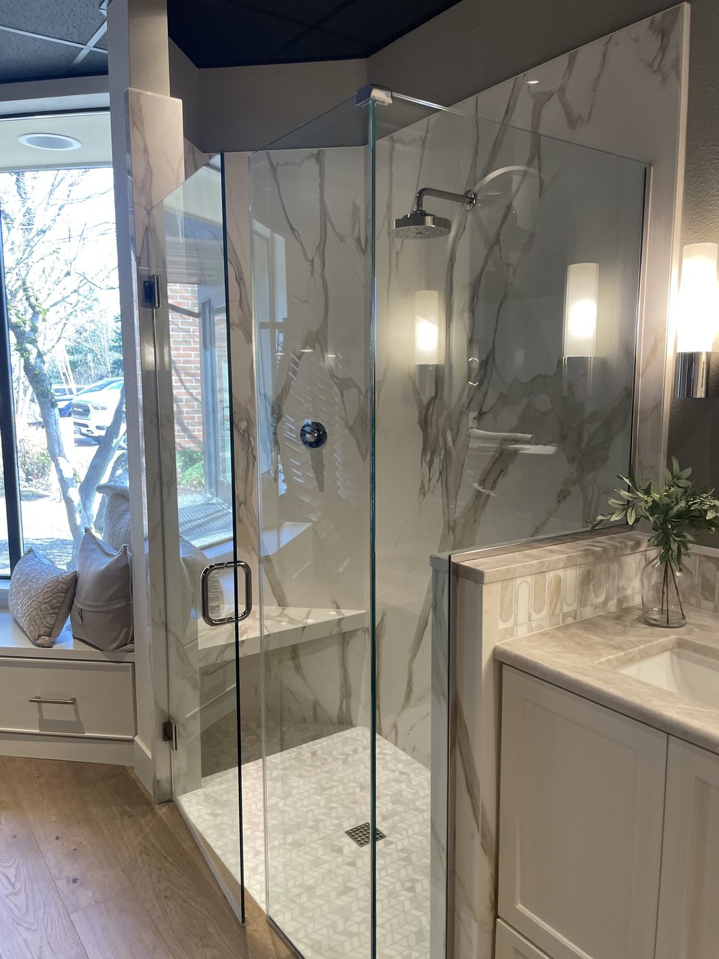 Shower in marble-look panels with a built-in bench and corner glass
