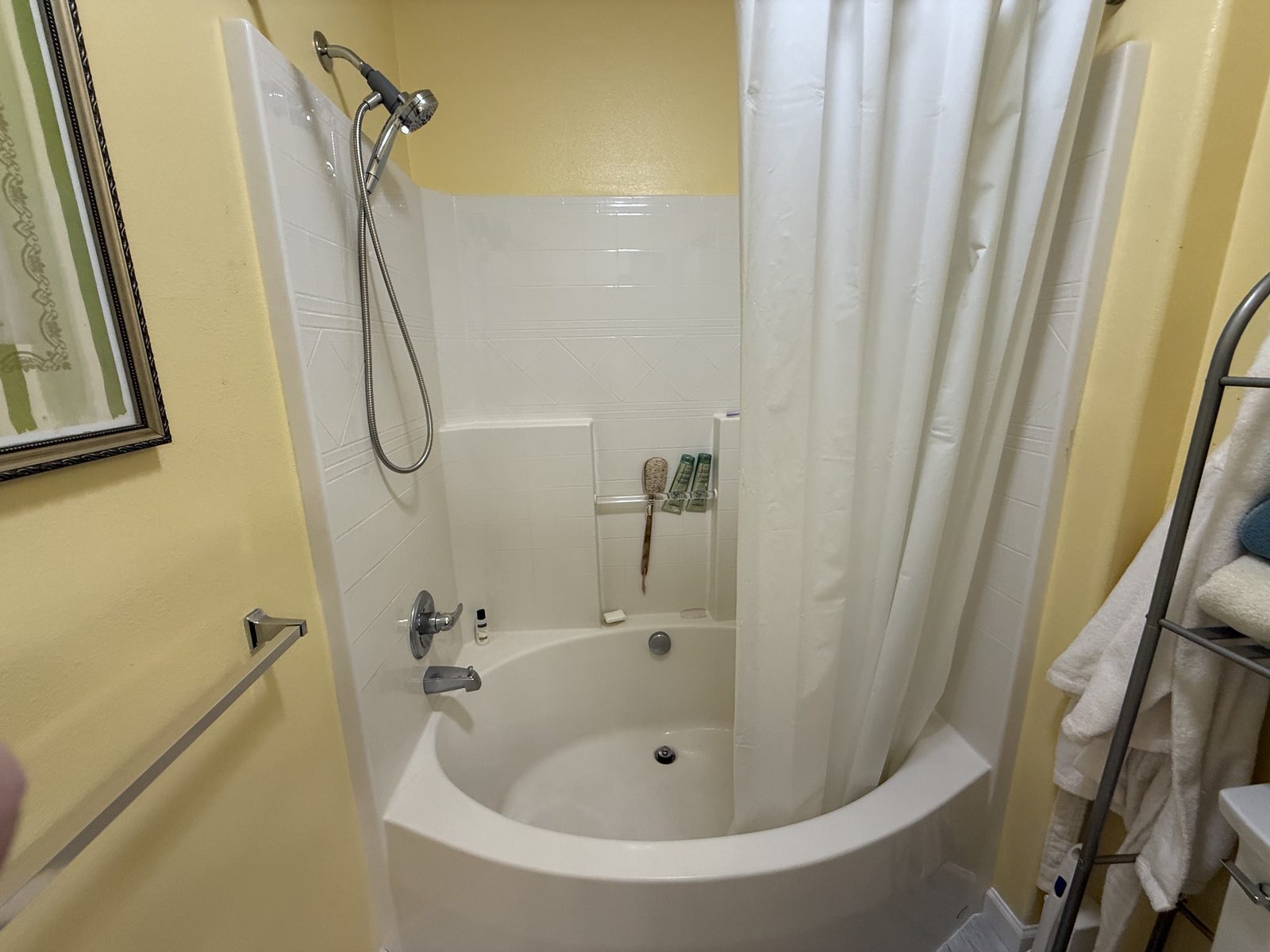 The original tub and shower combination behind a curtain